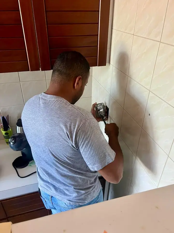 Profissional da Serviços Express instalando uma tomada elétrica